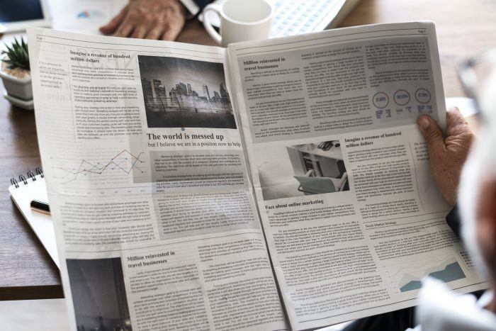 Business People Reading Newspaper 700x467